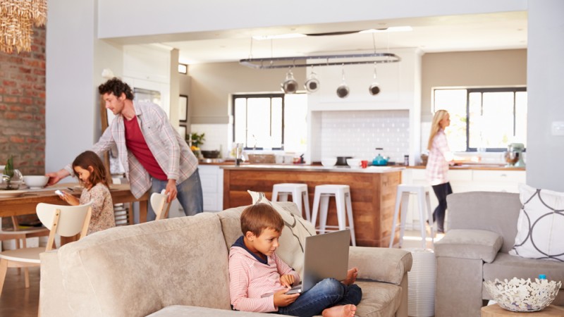 Une famille occupée au salon et dans la cuisine dans une maison à aire ouverte