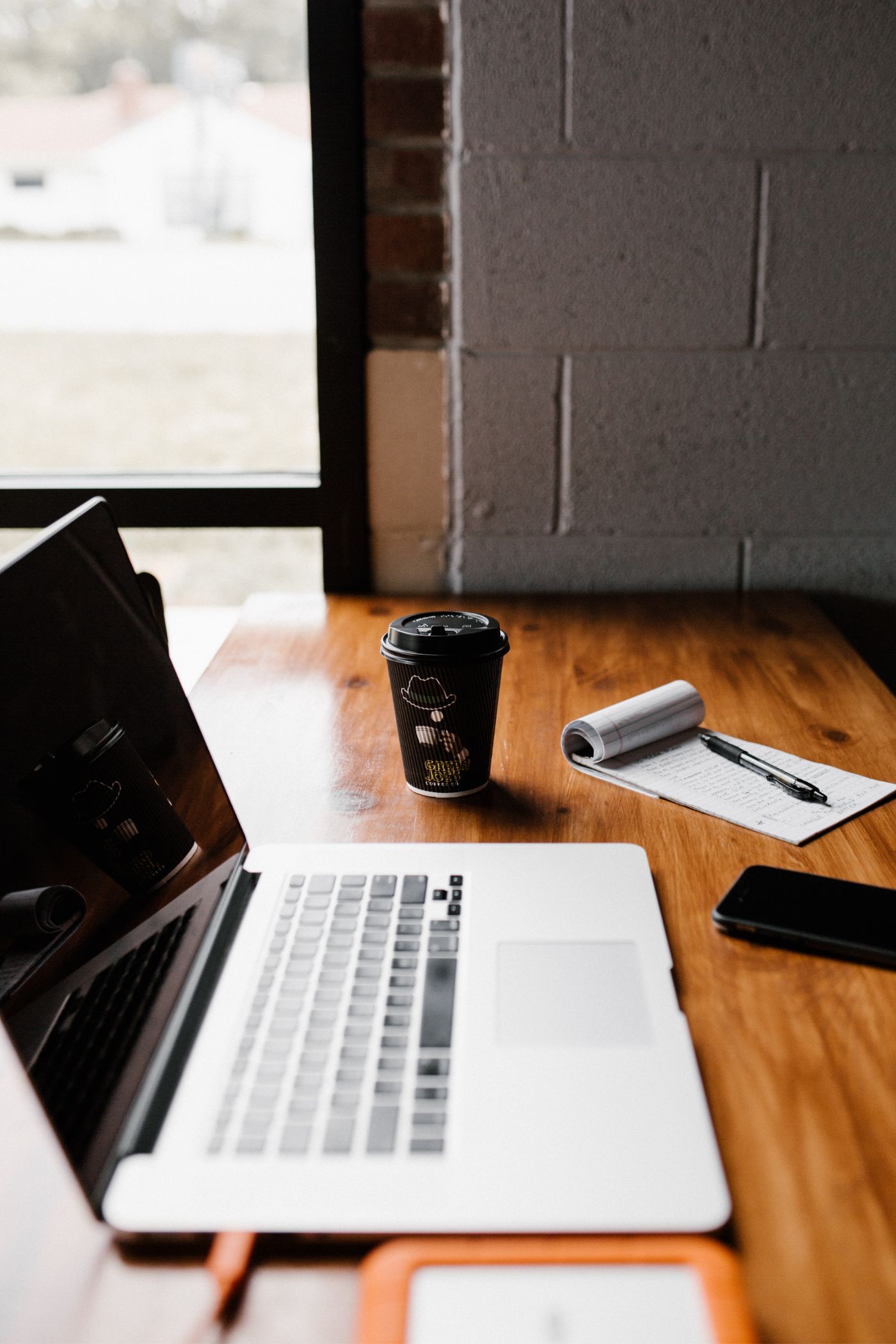 Table de bois avec ordinateur portable, téléphone, cahier de note et crayon - Une carrière exceptionnelle - Experts hypothécaire - Carrières | Multi-Prêts Hypothèques